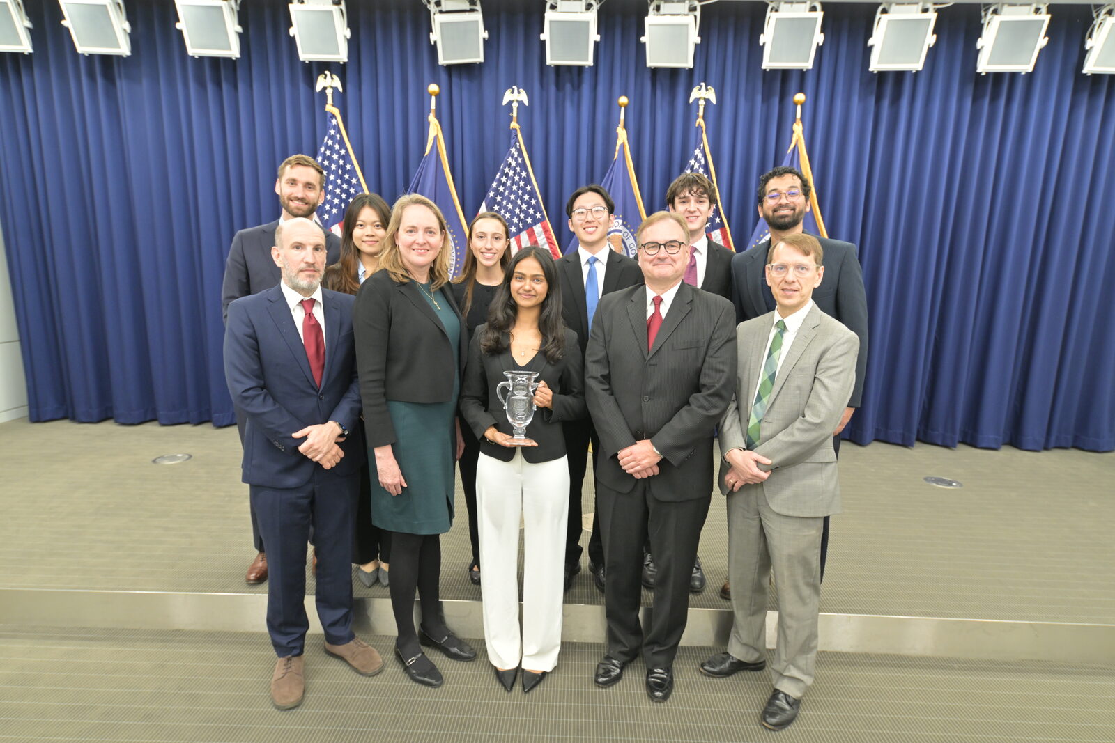 UCLA's 2025 College Fed Challenge team with the judges and the trophy